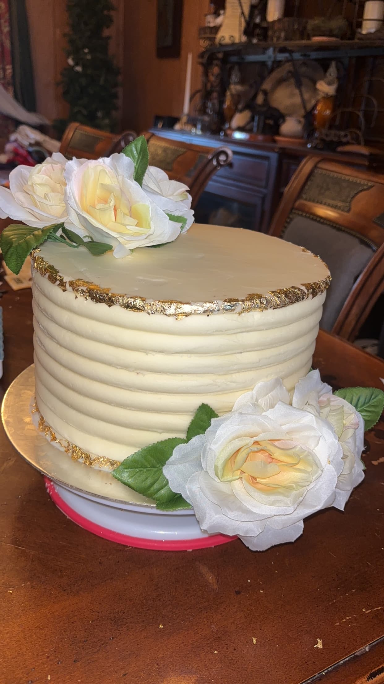 Elegant cream textured cake with white roses and gold leaf trim